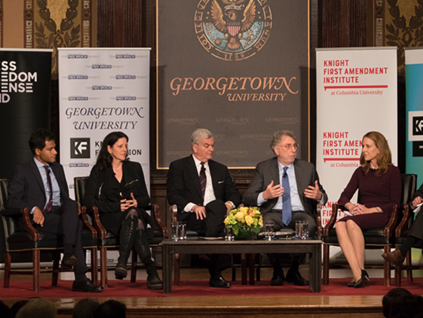 Panel of speakers with KFAI logo on banner